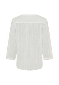 Blusa bianca ampia, con texture a righe verticali, maniche a tre quarti e scollatura rotonda. Tessuto leggero.