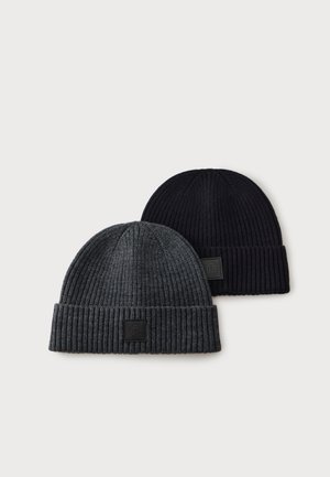 Zwei gerippte Strickmützen, eine dunkelgrau und eine schwarz, jeweils mit einem umgeschlagenen Bündchen und einem kleinen quadratischen Logopatch vorne.