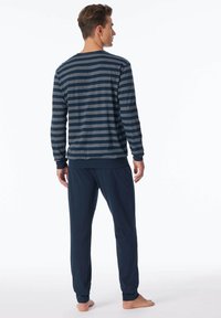Haut à manches longues rayé bleu marine et gris associé à un jogging bleu marine foncé. Fabriqué en tissu doux avec des poignets et une taille côtelés, coupe décontractée.
