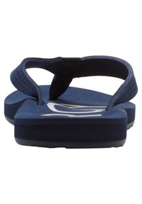 Navy blue flip-flop with a textured, soft footbed, rubber sole, and a contrasting white logo. Adjustable black thong strap at the top.