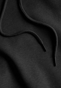 Tessuto di felpa nera con cordini intrecciati. Texture liscia con un leggero lucido. Colore nero profondo, dettagli visibili minimi.