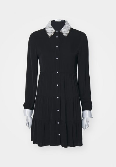 Vestido preto de mangas longas com um design em camadas, colarinho com pérolas, punhos prateados e fecho frontal com botões. Tecido suave e leve.