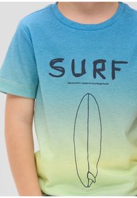 Kurzärmliges T-Shirt mit einem Farbverlauf von Blau zu Grün, versehen mit fettem schwarzen Text "SURF" und einer einfachen Kontur eines Surfbretts.