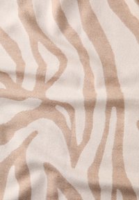 Beige stof med et zebra-stribemønster i lyse beige nuancer. Teksturen er blød og vævet med glatte, flydende linjer.