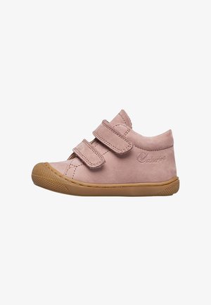 Zapato para toddler de ante rosa claro con dos correas de velcro y una suela de goma marrón, visto de lado sobre un fondo blanco.