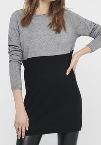 Robe pull à manches longues grise et noire ; en maille, col rond, design bicolore avec une texture lisse et des poignets côtelés.