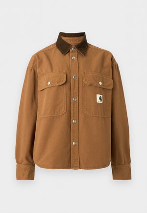 Braune Jacke mit Knopfleiste, dunkelbraunem Cordkragen, zwei vorderen Klappentaschen mit silbernen Druckknöpfen und einem kleinen rechteckigen Logoaufnäher auf der Brust.