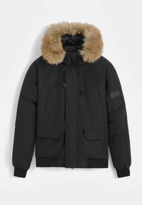 Veste isolante noire avec capuche en fausse fourrure, grandes poches avant et poche zippée sur la manche. Présente des poignets élastiques et un ourlet droit.