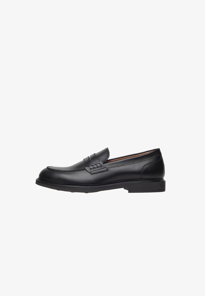 Mocasines de cuero negro con un tacón bajo, punta redondeada, costuras decorativas y un acento texturizado en la parte delantera. Acabado suave.