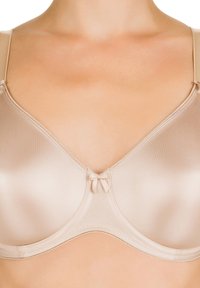 Reggiseno nudo con una finitura liscia e satinata, coppe leggermente sagomate, spalline trasparenti regolabili e un fiocco decorativo al centro.