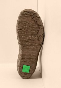 Suela de un zapato marrón con agarre texturizado, grabado "EL NATURALISTA", y un logo cuadrado verde con una rana cerca del talón.