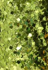 Zielony materiał z cekinami, zawierający kwadratowe i okrągłe odbijające kawałki, tworzący teksturową powierzchnię w różnych odcieniach zieleni.