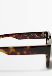 Sonnenbrille aus Schildpatt mit glänzender Textur und einem klaren Design. Die Beschriftung auf dem inneren Bügel enthält "P KATEGORIE 3" und das CE-Zeichen.