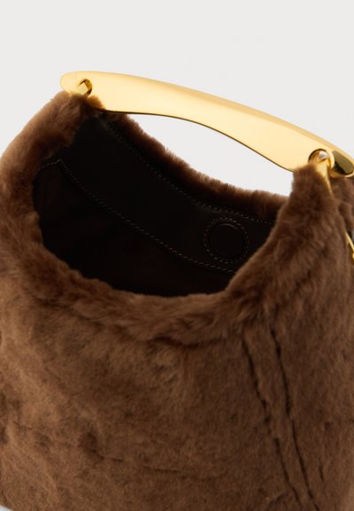 Pruun valejõhvahand, millel on kaardus kuldne käepide, must sisemus ja nähtavad õmblused. Pehme tekstuur, ümar kuju.