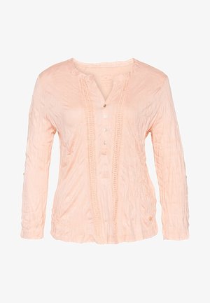 Lyserød bluse med lange ærmer og tekstureret stof, rund halsudskæring, tre knapper og lodrette blonde detaljer foran.
