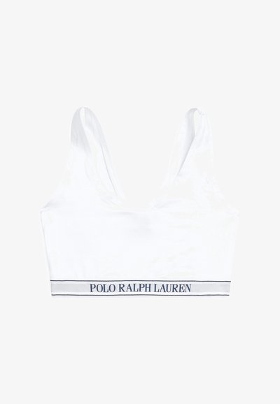 Λευκό, απαλό σουτιέν από ύφασμα με φαρδιές τιράντες και στρογγυλή λαιμόκοψη. Διαθέτει μπλε σκούρα λωρίδα με το λογότυπο "POLO RALPH LAUREN" στο κάτω μέρος.