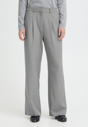 Hellgraue, weit geschnittene Hosen mit Falten, aus einem glatten Stoff gefertigt. Verfügen über einen taillierten Bund und Seitentaschen.