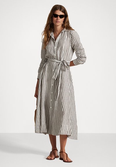 Vestido camisero largo a rayas en tejido ligero, con cierre de botones en la parte delantera, cintura ajustada con cinturón y mangas largas, con un dobladillo que llega por debajo de la rodilla.