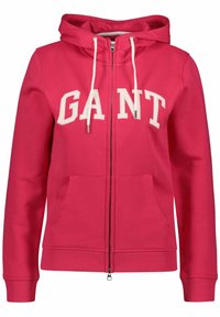 Roze hoodie met ritssluiting en een capuchon, witte trekkoorden en het 'GANT' logo in dikke letters. Beschikt over voorkruiken en geribbelde manchetten. Zachte stoftextuur.