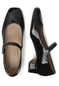 Scarpe Mary Jane nere in vernice con punta quadrata, cinturino alla caviglia, tacco basso e insole beige. Texture liscia con accenti minimi.