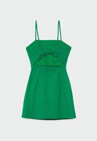 Robe verte sans manches avec fines bretelles réglables, un détail noué à l'avant et une découpe sous la poitrine, présentée sur un fond clair.