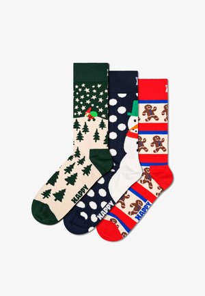 Drie paar feestelijke sokken: groen met bomen, marineblauw met witte stippen en een sneeuwman, rood met gembermannen en blauwe strepen.