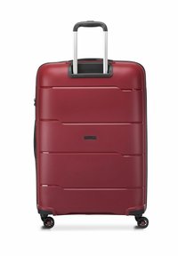 Maleta rígida roja con un diseño elegante, que cuenta con un mango telescópico, cuatro ruedas giratorias y patrones de surcos horizontales.