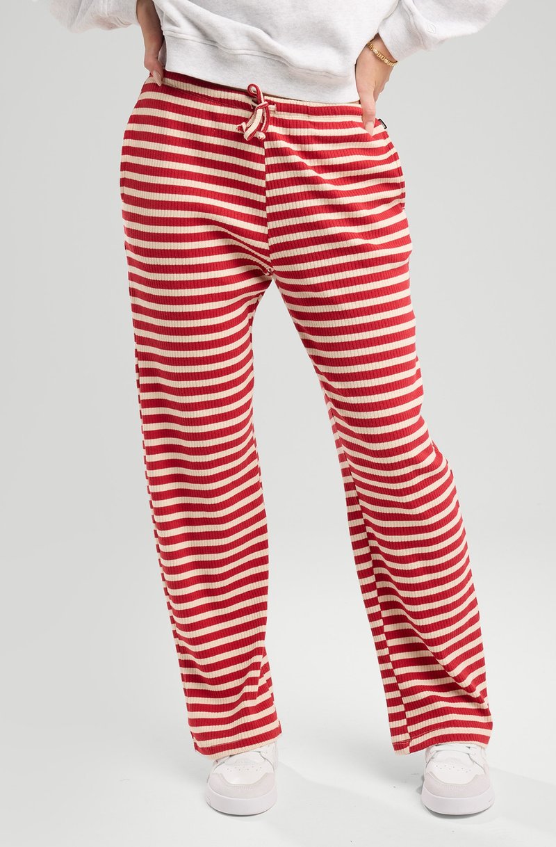 Red and beige striped lounge pants with a ribbed texture, elastic waistband featuring a drawstring, and side pockets.