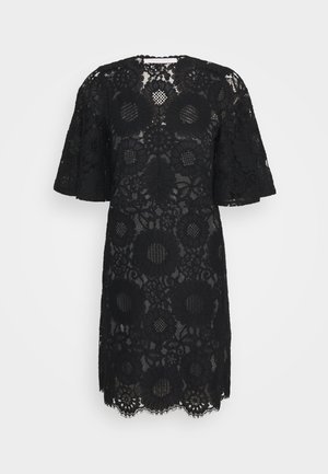 Vestido negro hasta la rodilla con un gran patrón de encaje floral, mangas cortas acampanadas y dobladillo con borde festoneado sobre un fondo liso.