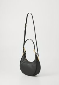 Sac à main en cuir noir avec une forme courbée, des accents en métal doré, une fermeture éclair et une bandoulière amovible. Texture lisse.