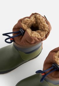 Bottes en caoutchouc vert imperméables avec un col matelassé marron, doublure en polaire et détail de cordon bleu. Semelles épaisses pour une meilleure adhérence.