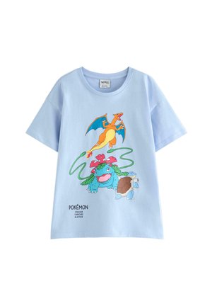 Lyseblå T-shirt med farverige illustrationer af Pokémon Charizard, Venusaur og Blastoise på forsiden med deres navne nedenunder.