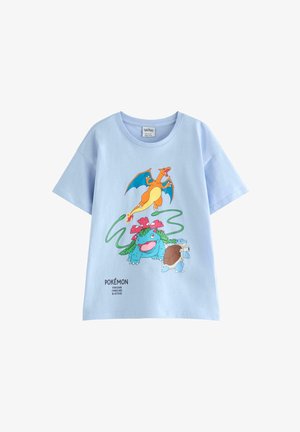 Lyseblå T-shirt med farverige illustrationer af Pokémon Charizard, Venusaur og Blastoise på forsiden med deres navne nedenunder.