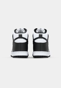 Vysoké tenisky v černé a bílé barvě, s hladkým koženým svrškem, polstrovaným límcem a bílou gumovou podrážkou se strukturovaným vzorkem.