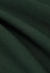 Țesătură ribbed de culoare verde închis, cu o textură netedă, prezentând pliuri și cute. Materialul pare elastic și moale, potrivit pentru diverse articole de îmbrăcăminte.