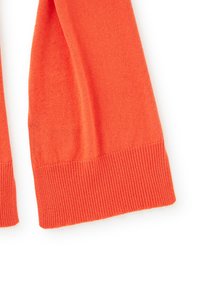 Maglione lavorato a maglia rosso-arancio con polsini a costine. Tessuto morbido con maniche lunghe e design dalla vestibilità rilassata. Tessuto leggero.