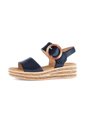 Navy leather sandal with two wide straps and a circular wooden accent. Features a textured cork wedge sole with layered design.