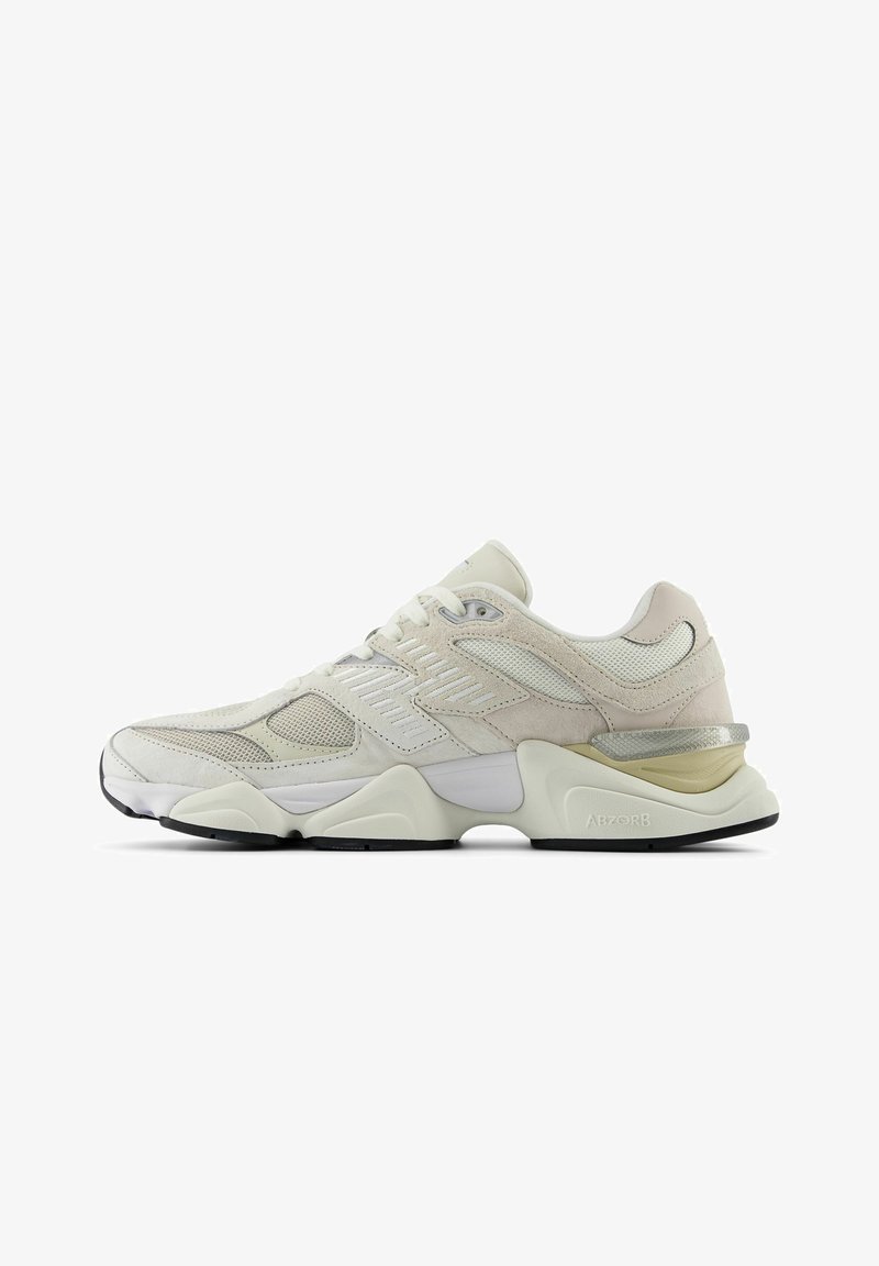 Hvit sneakers med mesh og semsket overdel, rund tå og polstret krage. Har reflekterende detaljer og en tykk, teksturert såle.