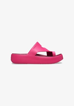 Roze rubberen slip-sandalen met een brede band en een verhoogde platformzool. Beschikt over een uitgesneden ontwerp en een gestructureerde onderkant voor grip.
