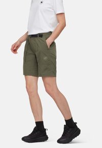 Olivgröna shorts med avslappnad passform, med plana fickor och en diskret logotyp på vänster ben. Tillverkade av lätt och andningsbart material.