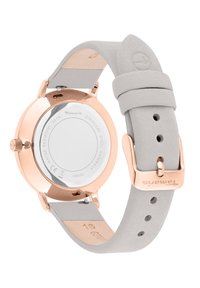 Gehäuse aus roségoldigem Edelstahl mit einem glatten weißen Zifferblatt. Hellgraues Lederarmband mit verstellbarer Schnalle. Wasserdicht bis 9 ATM.