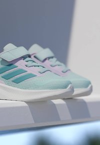 Αθλητικά παπούτσια ανοιχτού μπλε χρώματος με επάνω μέρος από διχτυωτό υλικό, με τόνους τυρκουάζ και λεβαντίνης, ομαλή υφή και λουράκι πάνω από το πέλμα.