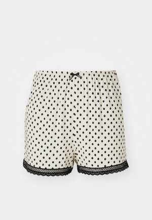 Polka dot shorts in cream with black spots, featuring a lace trim at the hem and an elastic waistband with a bow detail.