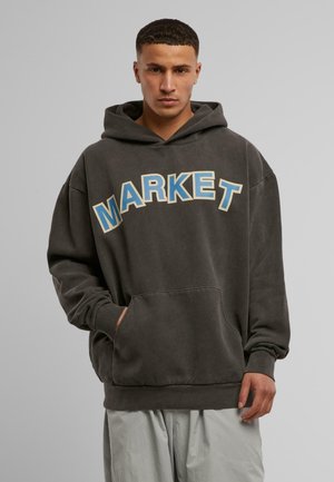 Dunkelgrauer, oversize Hoodie mit einer großen Fronttasche. Mit großem "MARKET"-Schriftzug in Hellblau und Creme. Weiches, strukturiertes Material.