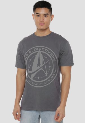 Gray cotton t-shirt featuring a central graphic of the U.S.S. Discovery emblem with text, short sleeves, and a standard fit.