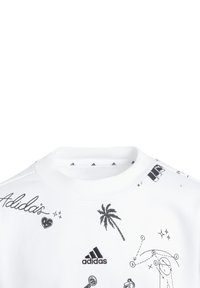 Felpa bianca con illustrazioni grafiche nere, tra cui una palma e vari simboli. Include il logo "Adidas" sul davanti. Materiale morbido.