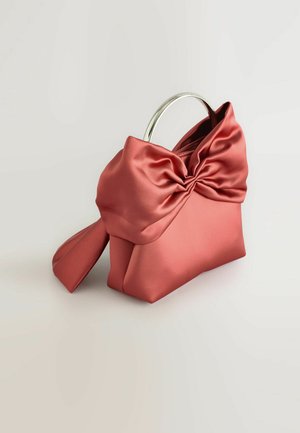 Koraline satiinhankega, millel on läikivast hõbedast ringikujuline käepide ja suur lipsuetendus esiosas, millel on pehme, sile tekstuur ja struktureeritud kuju.