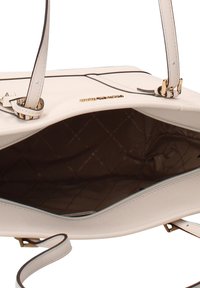 Sac beige clair à texture lisse, doté de ferrures dorées, d'une fermeture éclair et d'un intérieur avec une doublure matelassée marron.