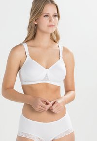 Soutien-gorge blanc en tissu lisse, avec des accents en dentelle et des bretelles réglables. Associé à une culotte blanche assortie avec une bordure en dentelle.
