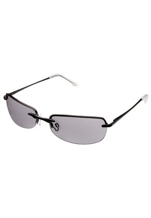 Gafas de sol con montura negra y lentes gris oscuro, brazos finos y puntas de las orejas de color crema; presentan un diseño minimalista y forma curvada.